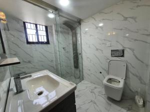 a white bathroom with a sink and a toilet at Grace - Residential home in Kathmandu