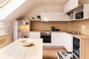 a kitchen with white cabinets and a bowl on a wooden table at Vigorous Bled Apartment in Bled
