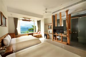 a bedroom with a bed and a tv and a window at Shangrila Leisure Farm in Dongshan
