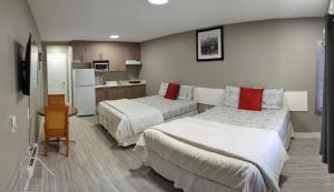 um quarto de hotel com duas camas e uma cozinha em Riverside Motel em Medicine Hat