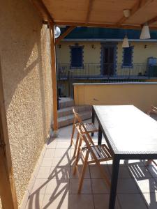 un tavolo e sedie su un patio con una casa di Battisti House a Besozzo