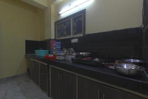a kitchen with a counter with a bunch of dishes at home Away From Home in Secunderabad