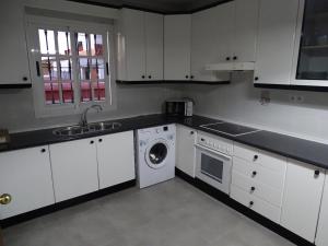 a kitchen with white cabinets and a washing machine at Casasjerezanas VistaFlor in Jerez de la Frontera