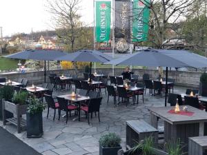 ein Restaurant mit Tischen, Stühlen und Sonnenschirmen in der Unterkunft Gasthof Bären in Ochsenfurt