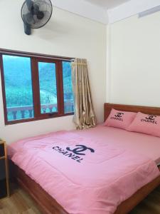 een slaapkamer met een roze bed en een ventilator bij HOMESTAY PAC BO CAO BẰNG in Cao Bằng