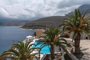 a resort with palm trees next to the water at Limeni Village in Limeni