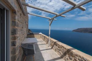 a balcony with a table and a view of the water at Limeni Village in Limeni