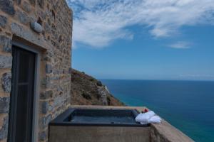 una ventana con vistas al océano desde un edificio en Limeni Village, en Limeni