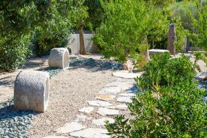 a garden with rocks and trees and trees at Luxury Jerini Estate in Krk