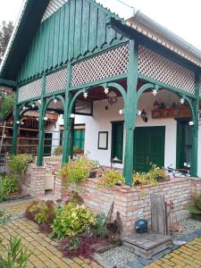 una casa con techo verde y algunas plantas en Veranda Vendégház, en Kismaros