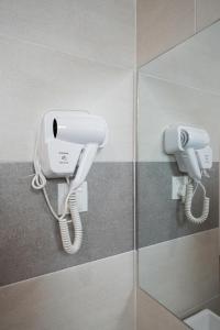 Hotel Le-Shore في كوالا سيلانجور: هاتف أبيض على جدار في الحمام