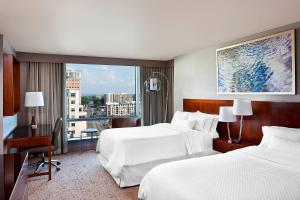 a hotel room with two beds and a large window at The Westin Arlington in Arlington