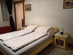 a bedroom with a bed and a table with a lamp at Veranda Vendégház in Kismaros