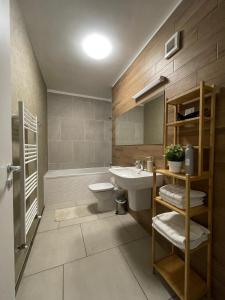 La salle de bains est pourvue d'un lavabo, de toilettes et d'une baignoire. dans l'établissement Anca Alphaville III, à Braşov