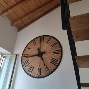 een grote klok aan een muur bij La corte dell'orologio in Endine Gaiano