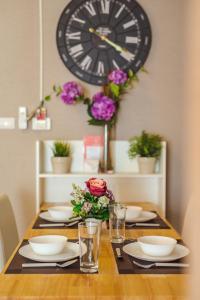 a dining room table with a large clock on the wall at Perfect Pool Apartment in Hua Hin