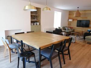 een woonkamer met een houten tafel en stoelen bij Les Briquettes in Mailly-Champagne