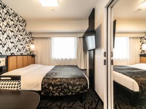 Postel nebo postele na pokoji v ubytování APA Hotel Osaka Temmabashi Ekimae