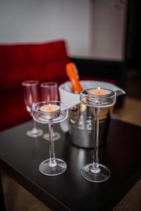 three candles sitting on a black table with glasses at GLAMOUR - Restaurant & SPA in Przeźmierowo