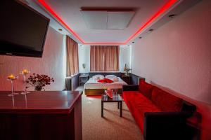 Cette chambre comprend un lit, un canapé et une télévision. dans l'établissement GLAMOUR - Restaurant & SPA, à Przeźmierowo