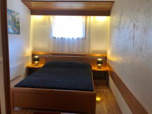 Cama pequeña en habitación pequeña con ventana en Apartman 602, en Kopaonik