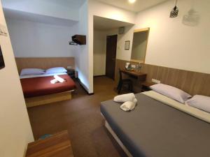 a hotel room with two beds and a desk at Hillview Inn Cameron Highlands PROMO in Tanah Rata