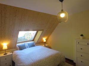1 dormitorio con 1 cama con ventana y 2 lámparas en Ático Dúplex reformado con vistas a la montaña en Canfranc-Estación