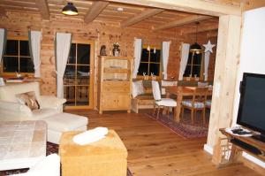 a living room with a couch and a dining room at Chalet Steiermark in Pusterwald