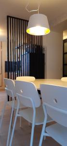 une table à manger avec des chaises blanches et un meuble lumineux dans l'établissement Gite La Volière Ouverte, à Valigny
