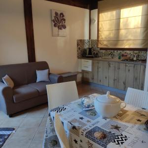 uma sala de estar com uma mesa e um sofá em Baglio Cracchiolo da Tuzzo - Villa Ulivo em San Vito lo Capo