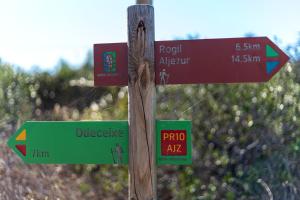 a wooden pole with street signs on it at Sunset Room - Hiking & Beach in Odeceixe