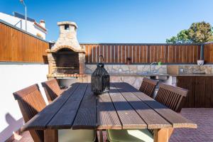 a wooden table on a patio with a fireplace at Sunset Room - Hiking & Beach in Odeceixe