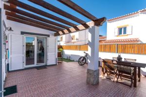 um pátio com uma pérgola de madeira e uma mesa em Sunset Room - Hiking & Beach em Odeceixe