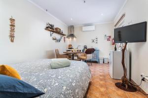 a bedroom with a bed and a flat screen tv at Sunset Room - Hiking & Beach in Odeceixe +43 photos