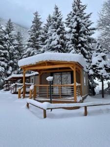 una cabaña en la nieve con árboles nevados en Gran Bosco Camping & Lodge, en Salabertano