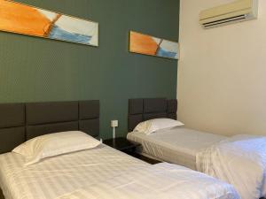 a room with two beds and two paintings on the wall at Hotel SMZ Sungai Siput (u) in Kampong Rimba Panjang