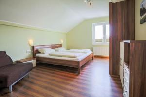 SahrensdorfにあるBuedlfarm-SuedOstのベッドルーム(ベッド1台、ソファ付)