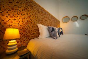 a bedroom with a bed with a wooden headboard and a lamp at Riad Shanima SPA Marrakech in Marrakesh