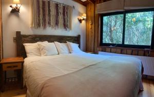 Una cama o camas en una habitación de Cabañas Natural Park Lodge Pucon