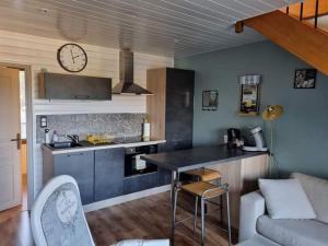 a kitchen with a counter top and a clock on the wall at Bulle de sel in Caudan