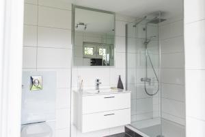 a white bathroom with a sink and a shower at Villa Talblick im Naturpark Altmühltal in Greding +82 photos