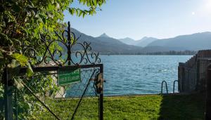 a gate with a sign in front of a lake at Aberseeblick Pension Ellmauer in St. Wolfgang