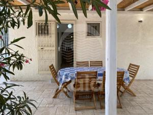 a table and chairs with a blue and white table cloth at Villa Sebastia - 100m dalla spiaggia By Cala Salento in Torre Lapillo