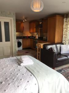 a living room with a bed and a kitchen at Moss Farm B&B in Knutsford