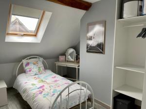 een kleine slaapkamer met een bed en een raam en planken bij Maison de village chez Josy in Coudun