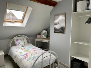 a small bedroom with a bed and a window and shelves at Maison de village chez Josy in Coudun