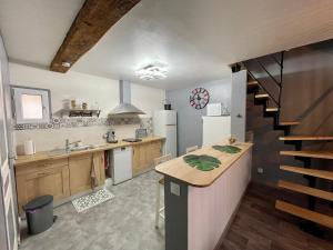 a kitchen with a counter and a staircase in a room at Maison de village chez Josy in Coudun