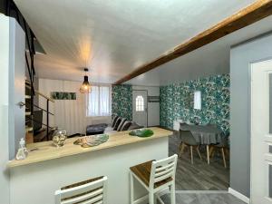 Maison de village chez Josy في Coudun: مطبخ وغرفة معيشة مع طاولة وكراسي