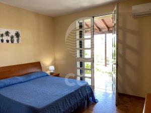 a bedroom with a bed and a sliding glass door at Villa Stella La tina - Spiaggia a 300m By Cala Salento in Torre Lapillo
