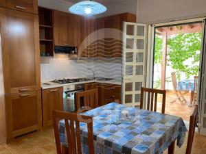 a kitchen with a table and a kitchen with a stove at Villa Stella La tina - Spiaggia a 300m By Cala Salento in Torre Lapillo